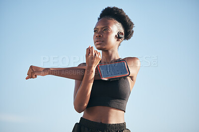 Buy stock photo Fitness, music and stretching with a black woman runner outdoor on a blue sky for cardio or endurance training. Exercise, body or phone with a young athlete getting ready for a sports workout