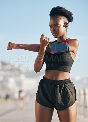 Buy stock photo Thinking, music and stretching with a sports black woman outdoor on a blurred background for cardio or endurance training. Fitness, exercise and phone with a young athlete getting ready for a workout