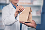 Woman, pharmacist and hands with medication for patient, healthcare or paper bag at the pharmacy. Closeup of female person or medical professional giving pills, drugs or pharmaceuticals to customer