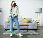 Woman, broom and singing with headphones for cleaning home, comic performance or music in living room. Girl cleaner, dancing and funny karaoke with energy, performance or streaming audio in lounge