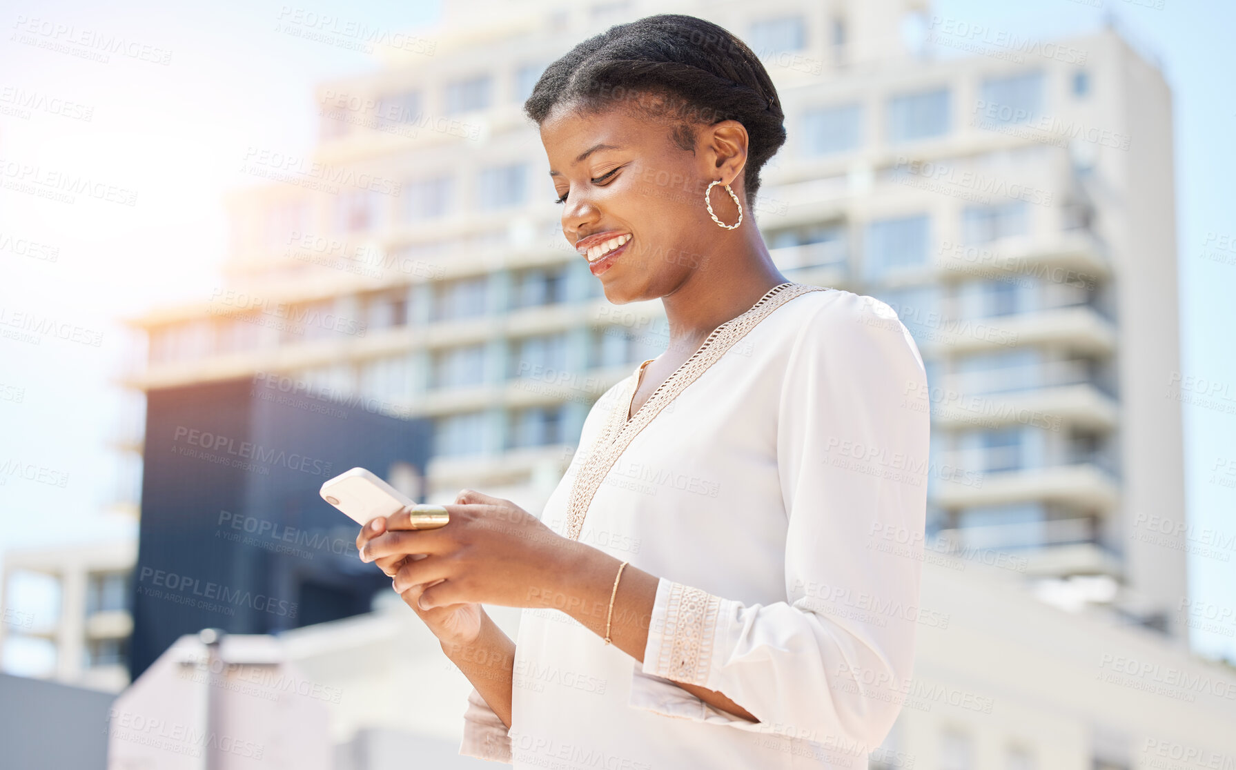 Buy stock photo Phone, city and commute with a business black woman typing a text message while walking to work outdoor. Mobile, social media or networking and a happy female employee in an urban town with flare