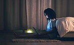 Laptop, night and woman in her bedroom networking on the internet, social media or website. Technology, dark and female person doing research or browsing online with a computer in her apartment.