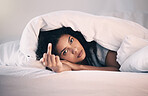 Angry, woman with insomnia and portrait in bed with a middle finger for morning or waking up, sleeping in bedroom or at home. Hand, show a curse sign and frustrated with sleep problem at night