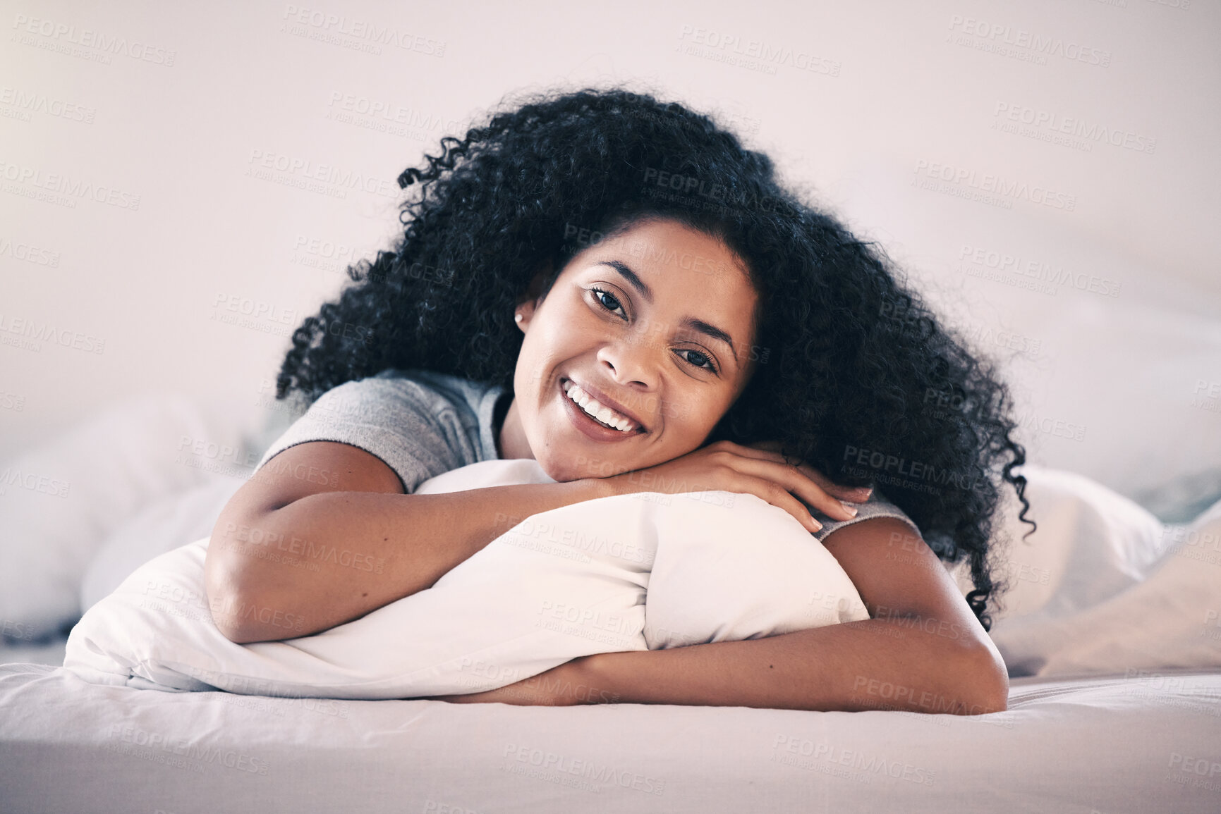 Buy stock photo Happy, smile and portrait of a woman in bed relaxing in the morning on a weekend at her home. Happiness, rest and calm young female person from Colombia lying in the bedroom of her modern apartment.