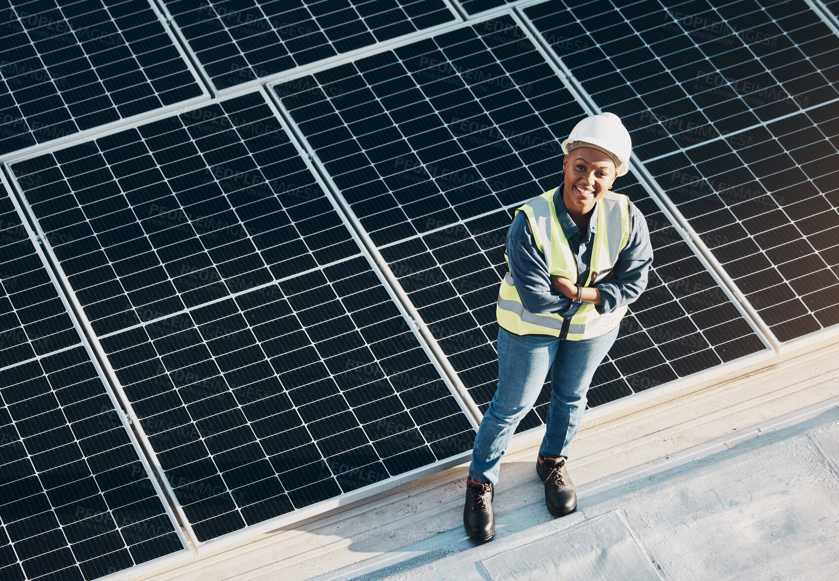 Buy stock photo Woman, solar panel construction and arms crossed portrait with a smile for engineering and green energy. Labor, happy and African female employee on industrial site outdoor for eco project from above