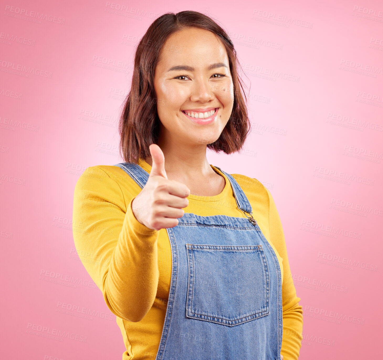 Buy stock photo Smile, thumbs up and yes with portrait of woman in studio for support, agreement and motivation. Winner, emoji and success with person on pink background for achievement, thank you and vote sign