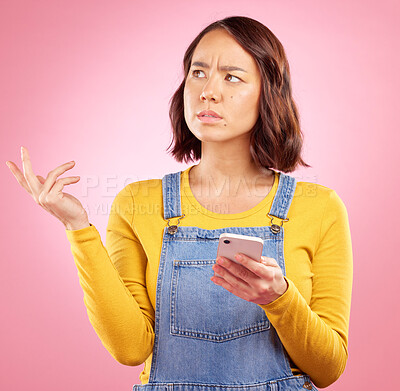 Buy stock photo Thinking, studio and Asian woman with cellphone problem, bad news and stress over mistake, crisis or social media post. Frustrated, doubt and person confused over smartphone glitch on pink background