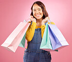Smile, shopping bag and sale with portrait of woman in studio for discount, fashion and deal. Product, retail and luxury with face of female customer on pink background for market, mall and store