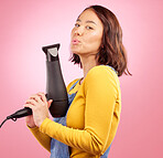 Hairdryer, salon and kiss  with portrait of woman in studio for hairdresser, beauty and cosmetics. Shampoo, hair care and hairstyle with face of person on pink background for product and glow