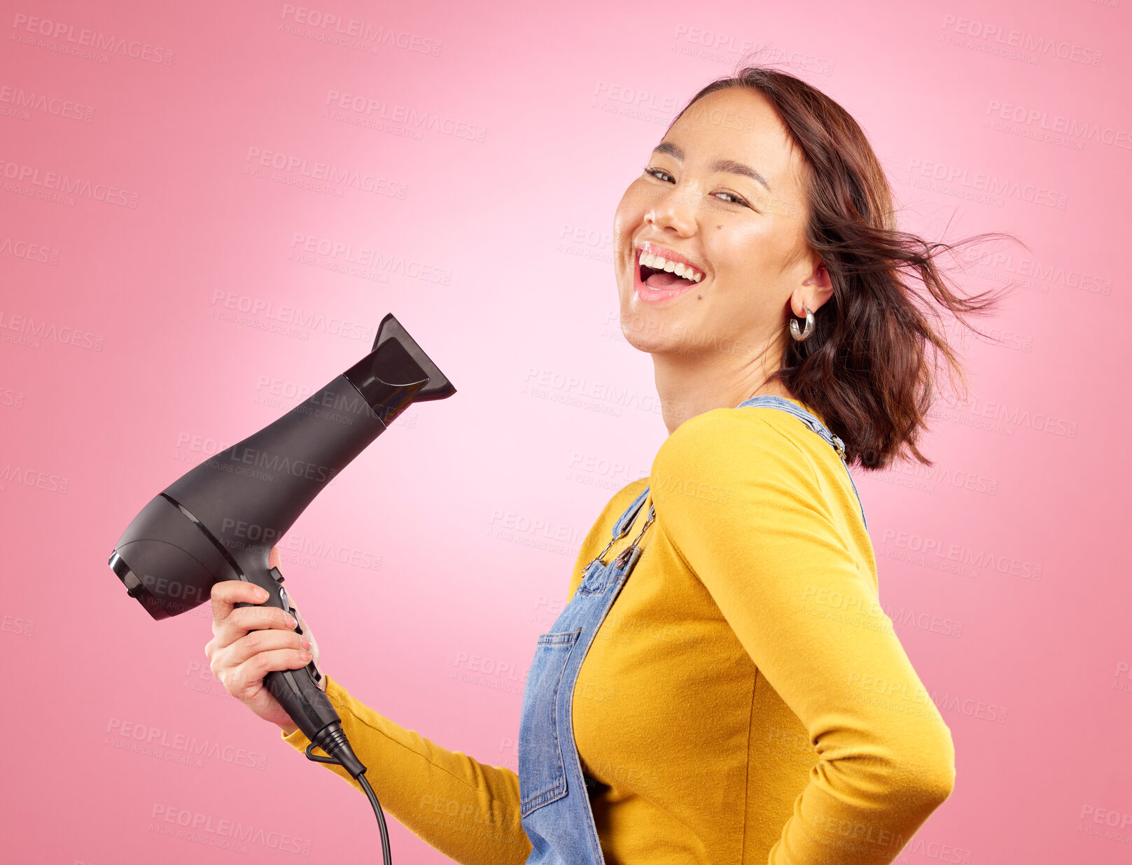 Buy stock photo Wind, salon and hair care with woman and hairdryer in studio for hairdresser, beauty and cosmetics. Shampoo, smile and hairstyle with portrait of asian person on pink background for product and spa