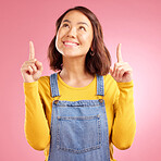 Happy, pointing and young woman in a studio for presentation for marketing, promotion or advertising. Smile, confident and Asian female model with showing finger gesture isolated by a pink background