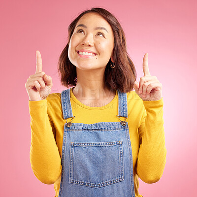 Buy stock photo Happy, pointing and young woman in a studio for presentation for marketing, promotion or advertising. Smile, confident and Asian female model with showing finger gesture isolated by a pink background