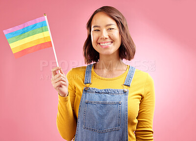 Buy stock photo Woman, pride flag and studio portrait for smile, lgbtq goals and vote for love by pink background. Gen z student girl, gay icon or symbol for protest, voice or opinion for power, equality and rainbow