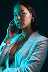 Neon, beauty and portrait of woman in studio with blue light for stylish, classy or formal fashion. Style, cosmetic and young Asian female model with makeup and fancy blazer by dark black background.