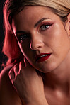 Portrait, beauty and makeup with a model woman in studio on a dark background in red lighting for desire. Face, skincare or cosmetics with a young female person posing for natural feminine confidence