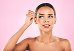 Face, pain and woman with tweezer for eyebrow in studio isolated on a pink background. Beauty, facial plucking and hair removal of model for self care, skincare and wellness, aesthetic and cosmetic