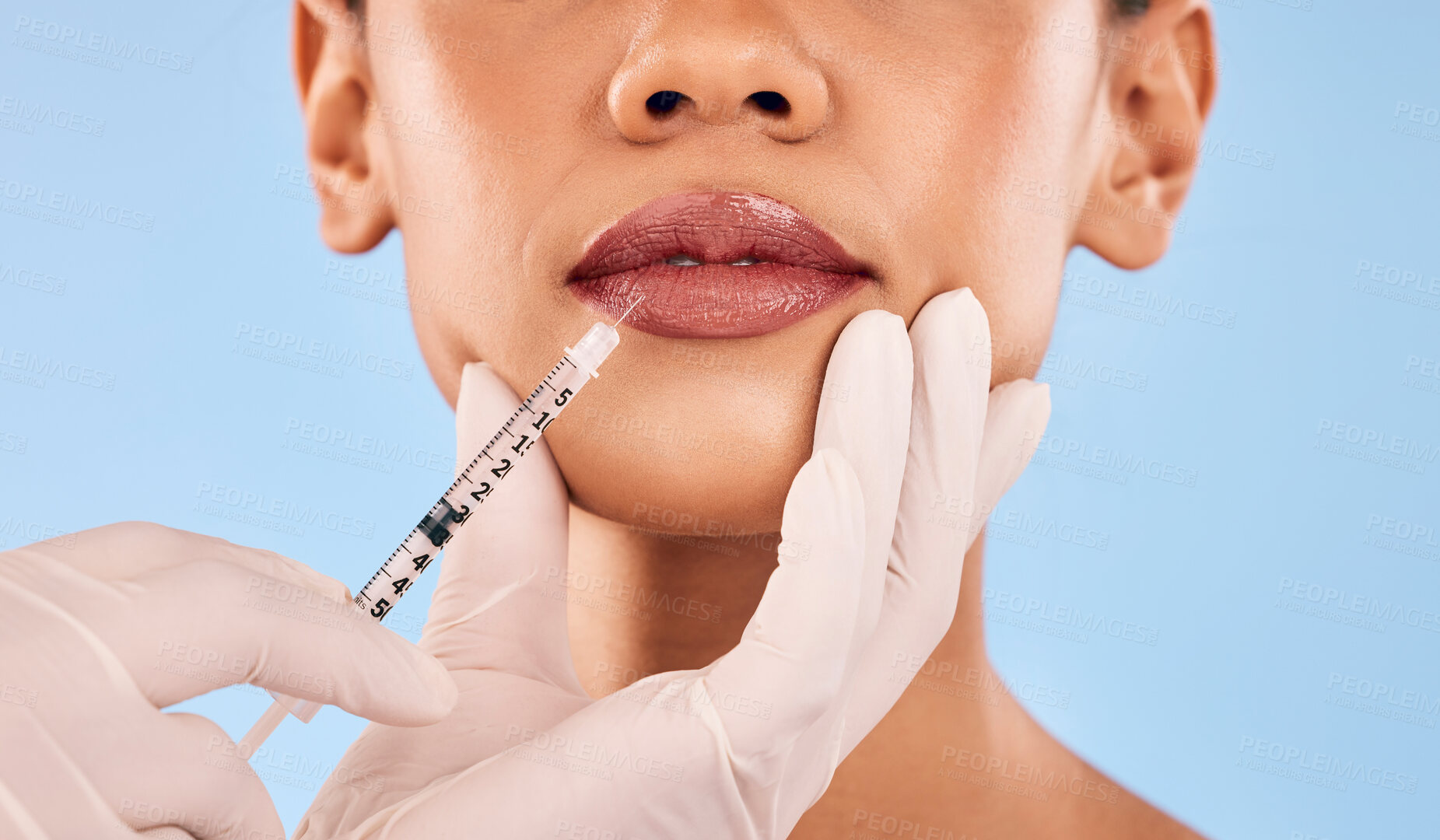 Buy stock photo Lip filler, injection and beauty, woman and cosmetic surgery closeup and dermatology on blue background. Face, skincare and syringe, female model and doctor hands with liquid collagen in studio