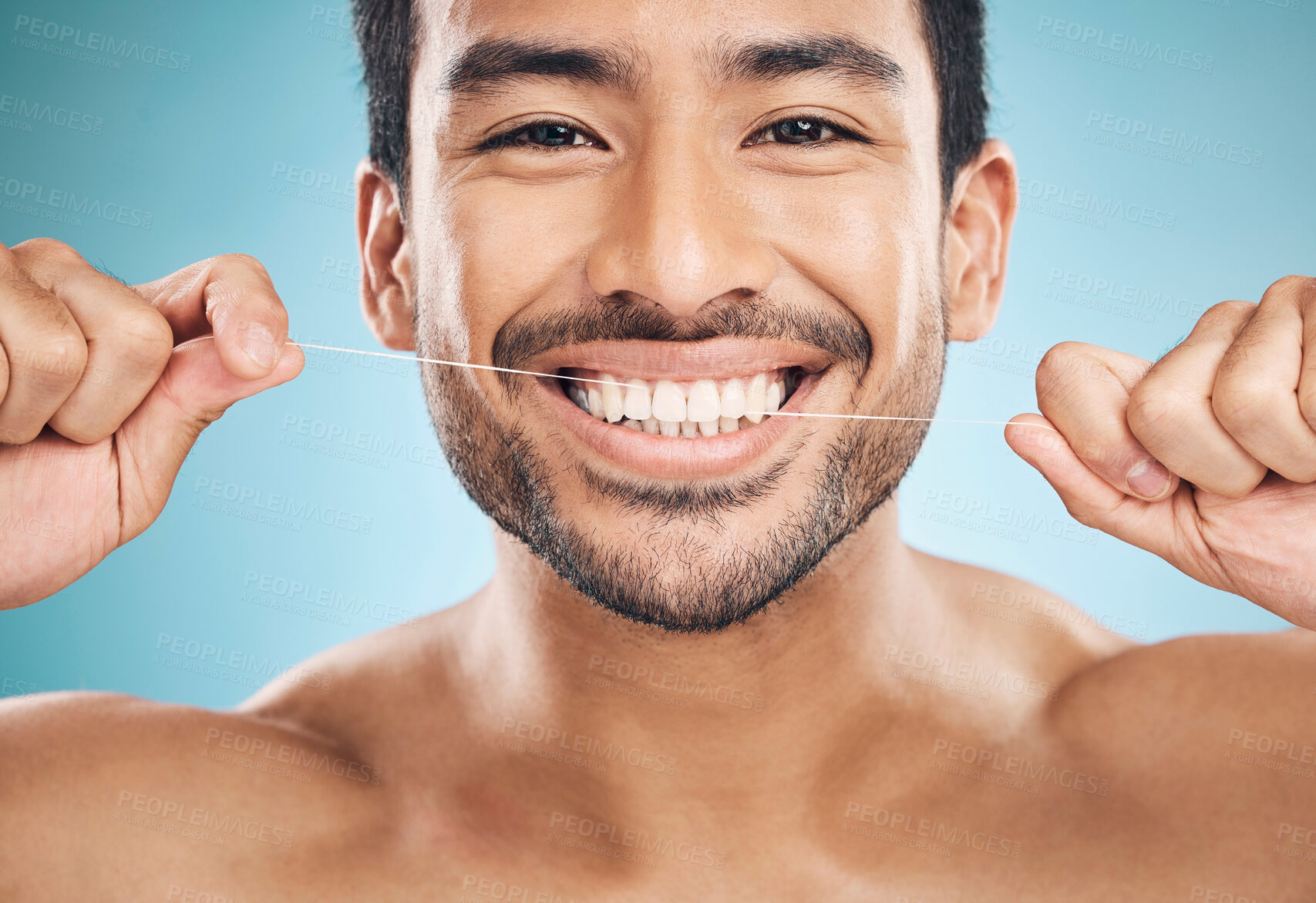 Buy stock photo Wellness, teeth and flossing of a man portrait with cleaning and dental health in a studio. Face, blue background and healthy male person with dental floss for mouth hygiene and healthcare with smile