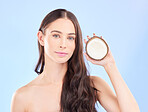 Hair, coconut oil and beauty, woman and cosmetic care with natural treatment on blue background. Female model, haircare and portrait, eco friendly fruit product for growth and shine in a studio