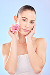 Woman, portrait and rose for skincare in studio, eco cosmetics and natural aesthetic facial on blue background. Face, female model and beauty of pink flowers, sustainable shine and floral dermatology