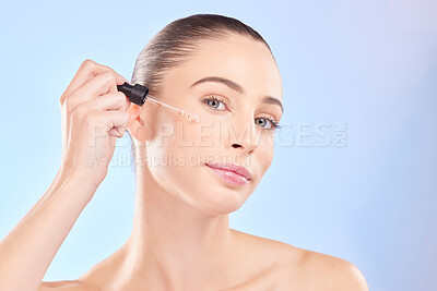 Buy stock photo Woman, portrait and oil serum for face, aesthetic skincare and dermatology on blue background. Female model, facial cosmetics and dropper of hyaluronic acid, liquid collagen and beauty glow in studio
