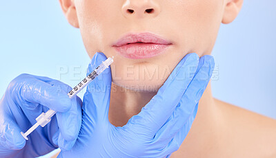 Buy stock photo Injection, woman and lips with plastic surgeon for beauty with botox or hands in studio with blue background. Face, syringe and doctor for injecting mouth with collagen or filler and implants.