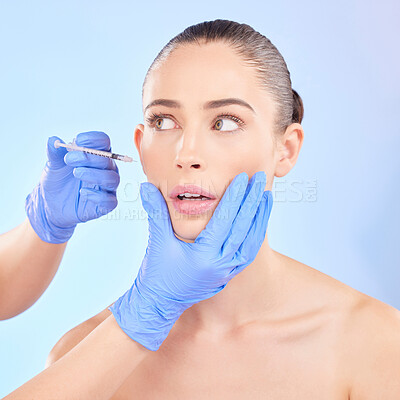 Buy stock photo Face, beauty and woman with plastic surgeon or injection for transformation in studio with blue background. Girl, filler and skincare for cosmetic with collagen or fear for doctor hands with syringe.