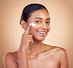 Face, cream and portrait of happy indian woman, makeup cosmetics and skincare dermatology on studio background. Young female model, lotion and facial sunscreen for clean beauty, shine and self care