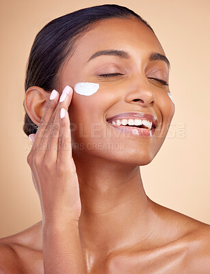 Buy stock photo Woman, happy skincare and cream for facial beauty, apply lotion and dermatology or cosmetics. Skin care product, face and young person or model sunscreen or moisturizer on a brown studio background