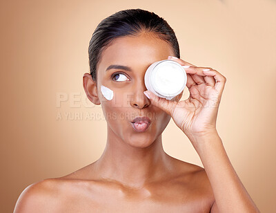 Buy stock photo Woman, cream container thinking of eye skincare, dermatology health and cosmetics. Facial product, kiss face and young person or beauty model with skin care lotion on a studio, brown background