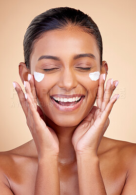 Buy stock photo Cream, face and happy woman for beauty cosmetics, dermatology or aesthetic makeup on studio background. Indian female model, lotion and smile with facial sunscreen for clean skincare, glow and shine
