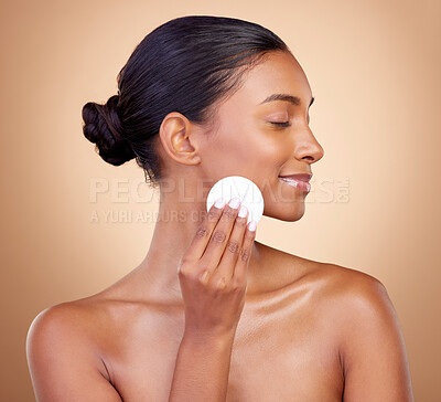 Buy stock photo Woman, cotton pad and skincare of face cosmetics for aesthetic wellness on studio background. Happy indian female model, clean beauty and facial dermatology product for makeup removal, shine and glow