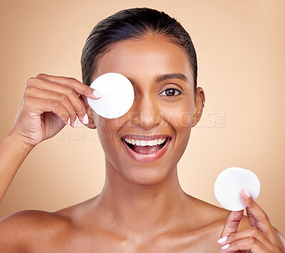 Buy stock photo Happy woman, cotton pad and skincare for eyes, face or aesthetic cosmetics on studio background. Portrait of indian female model, beauty and facial product for makeup, toner wipe or clean dermatology