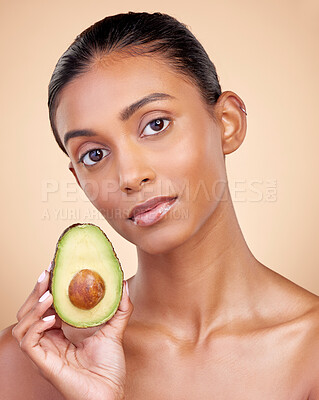 Buy stock photo Avocado, skincare and woman in portrait for healthy face and natural beauty on studio brown background. Young indian person or model with green fruits, vitamin c benefits and dermatology or cosmetics