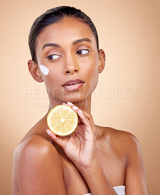 Buy stock photo Woman, thinking and cream with lemon for skincare, cosmetics and natural beauty product or vitamin c benefits. Facial sunscreen of young person with fruits for dermatology on studio, brown background