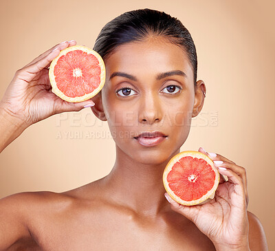 Buy stock photo Grapefruit, portrait and skincare of woman in studio for vitamin c wellness, vegan cosmetics and dermatology. Face of indian female model, natural beauty and healthy citrus for facial aesthetic shine