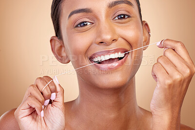 Buy stock photo Woman, tooth and floss in studio portrait with smile, cleaning or self care by brown background. Girl, model and happy for dentistry product, string or teeth whitening for cosmetics, beauty or health