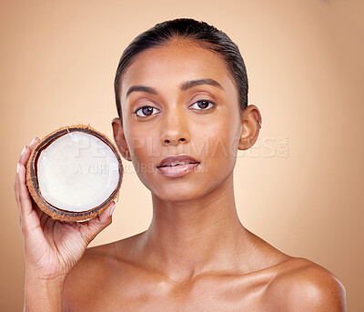 Buy stock photo Woman face, coconut fruit and beauty, healthy skincare or vegan cream on brown studio background. Portrait of Indian person in natural product for dermatology, eco friendly cosmetics and oil benefits
