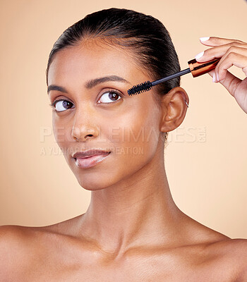 Buy stock photo Beauty, makeup and mascara with face of woman in studio for cosmetics, eyelashes and glamour. Self care, application and tools with female model on brown background for product, volume and glow