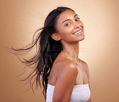 Buy stock photo Salon, hairstyle and beauty with indian woman or shine  in brown studio background. Haircare, shine and happy face with wind or growth for glow with keratin treatment in mockup or natural cosmetics.