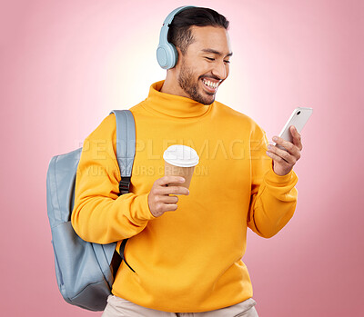 Buy stock photo Backpack, phone and man listening to headphones or college podcast, travel and coffee on pink background. E learning mobile and person with bag, music or audio streaming and university chat in studio