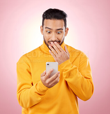 Buy stock photo Phone, wow or gossip with a surprised man in studio on pink background reading fake news announcement online. Mobile, shock and wtf with a young male person on a social media website or the internet