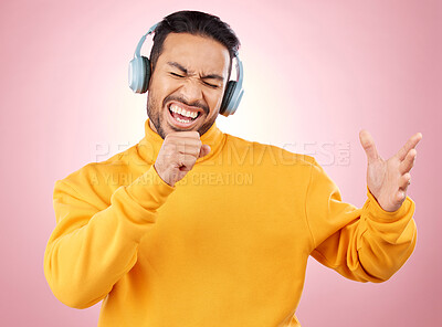 Buy stock photo Asian man, headphones and listening to music while singing for karaoke against a pink studio background. Happy male person enjoying online audio streaming, sound track or songs with headset on mockup