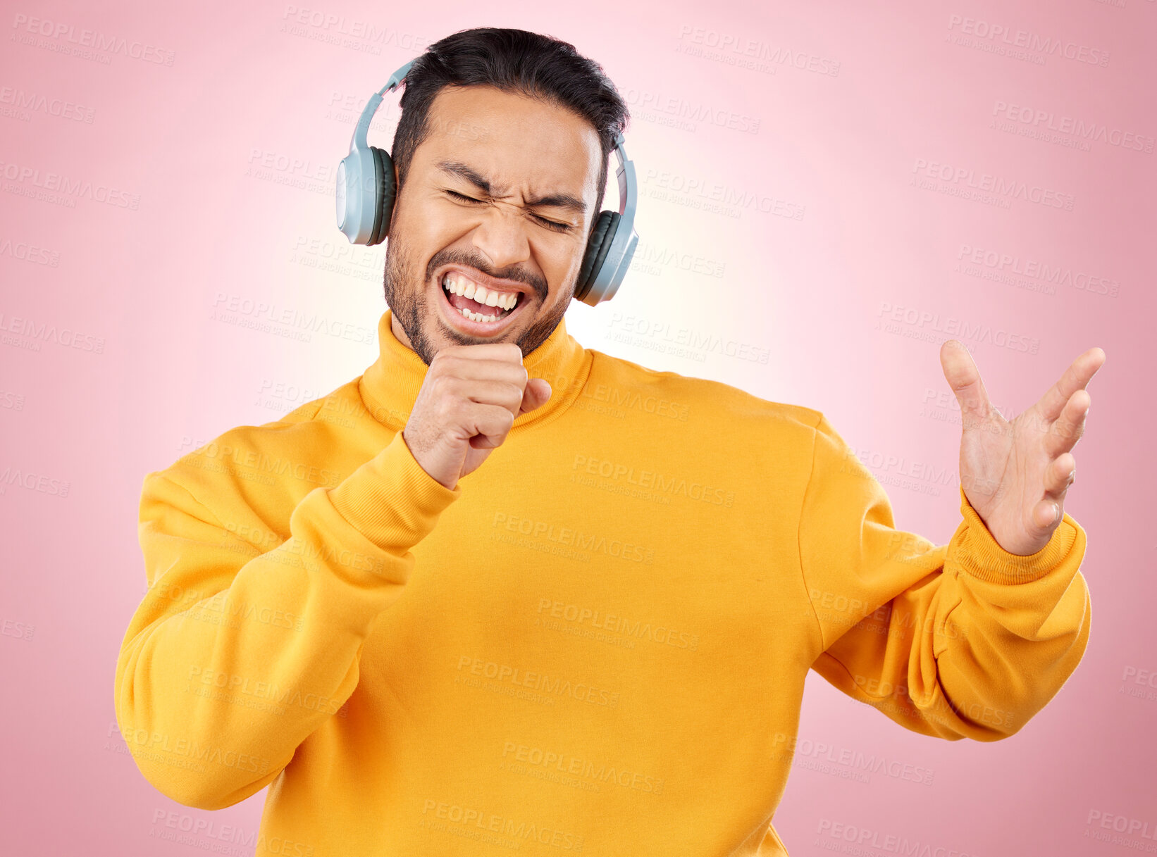 Buy stock photo Asian man, headphones and listening to music while singing for karaoke against a pink studio background. Happy male person enjoying online audio streaming, sound track or songs with headset on mockup