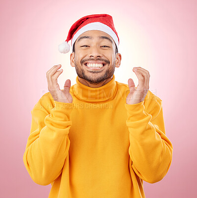 Buy stock photo Portrait, excited and happy man with Christmas hat, fun and festive for holiday on pink background. Happiness, celebration and model with smile, santa cap and winter vacation fashion jersey in studio