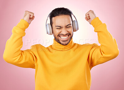 Buy stock photo Music, headphones and man or winner success, yes and celebration for podcast, radio news and bonus. Motivation, power and happy person dance, listening to audio and excited on studio pink background