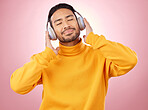 Happy, listening and man with headphones, music and stress relief against a studio background. Male person, audio and model with headset, streaming sounds and happiness with song, radio and podcast