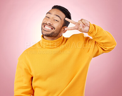 Buy stock photo Happy, peace sign and portrait of man in studio for support, kindness and emoji. Smile, happiness and thank you with face of person on pink background for mindfulness, vote and v hand gesture