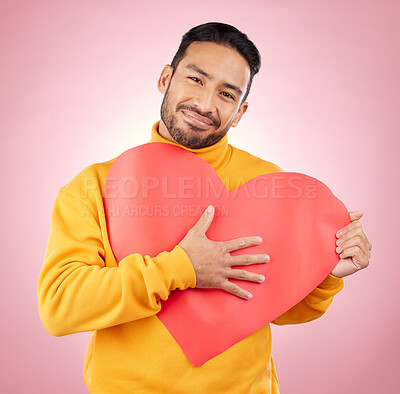 Buy stock photo Heart, poster and love with portrait of man in studio for romance, date and valentines day. Kindness, support and hope with person and sign on pink background for wellness, peace and creative mockup