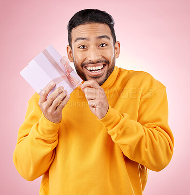 Buy stock photo Young man, gift box and studio portrait with excited smile, ribbon and open for celebration by pink background. Asian gen z student, present or prize for giveaway, competition or package for party